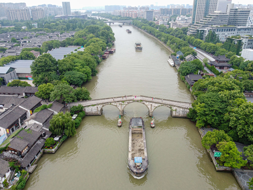 5月27日，一艘貨船駛過京杭大運河南端標志建筑杭州拱宸橋。(無人機照片)新華社記者江漢 攝