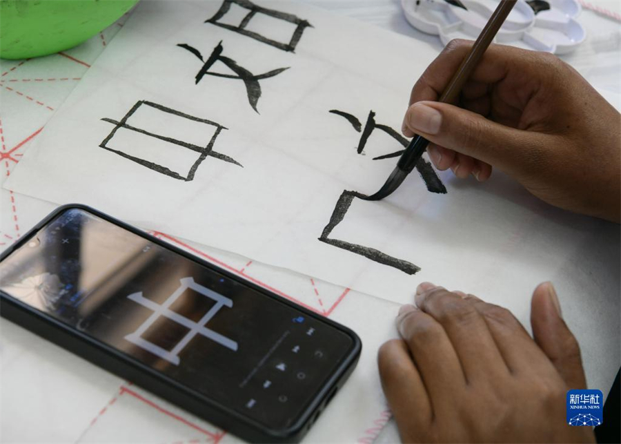 4月18日，肯尼亞學(xué)生在內(nèi)羅畢大學(xué)孔子學(xué)院舉辦的活動上寫毛筆字。肯尼亞內(nèi)羅畢大學(xué)孔子學(xué)院18日舉辦“中文，增進(jìn)文明對話”主題活動，慶祝即將到來的第14個聯(lián)合國中文日。肯尼亞學(xué)生參與互動，進(jìn)行書法、剪紙、唱中文歌等活動。新華社記者 韓旭 攝