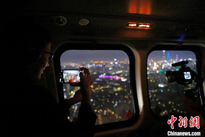 6月3日晚，游客乘坐上海新空直升機有限公司直升機開啟鳥瞰黃浦江空中圓夢之旅，并用手機拍攝城市夜景。　殷立勤 攝