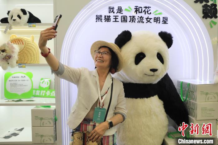 美國華視總裁楊蓮花與大熊貓文創產品合影。　王磊 攝