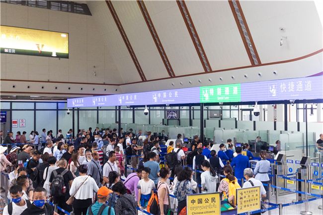 7月22日，乘坐中老鐵路國際旅客列車的旅客在磨憨邊檢大廳排隊候檢。衛海林 攝