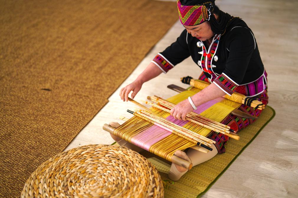 4月17日，黎族傳統(tǒng)紡染織繡技藝國(guó)家級(jí)代表性傳承人劉香蘭在2023年意大利米蘭設(shè)計(jì)周上展示黎錦織造技藝。新華社發(fā)