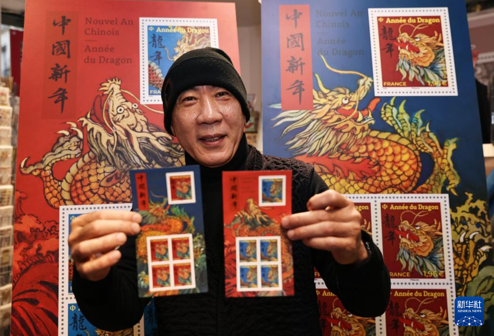 1月26日，在法國巴黎舉行的發行儀式上，郵票設計者陳江洪展示龍年生肖紀念郵票。新華社記者 高靜 攝