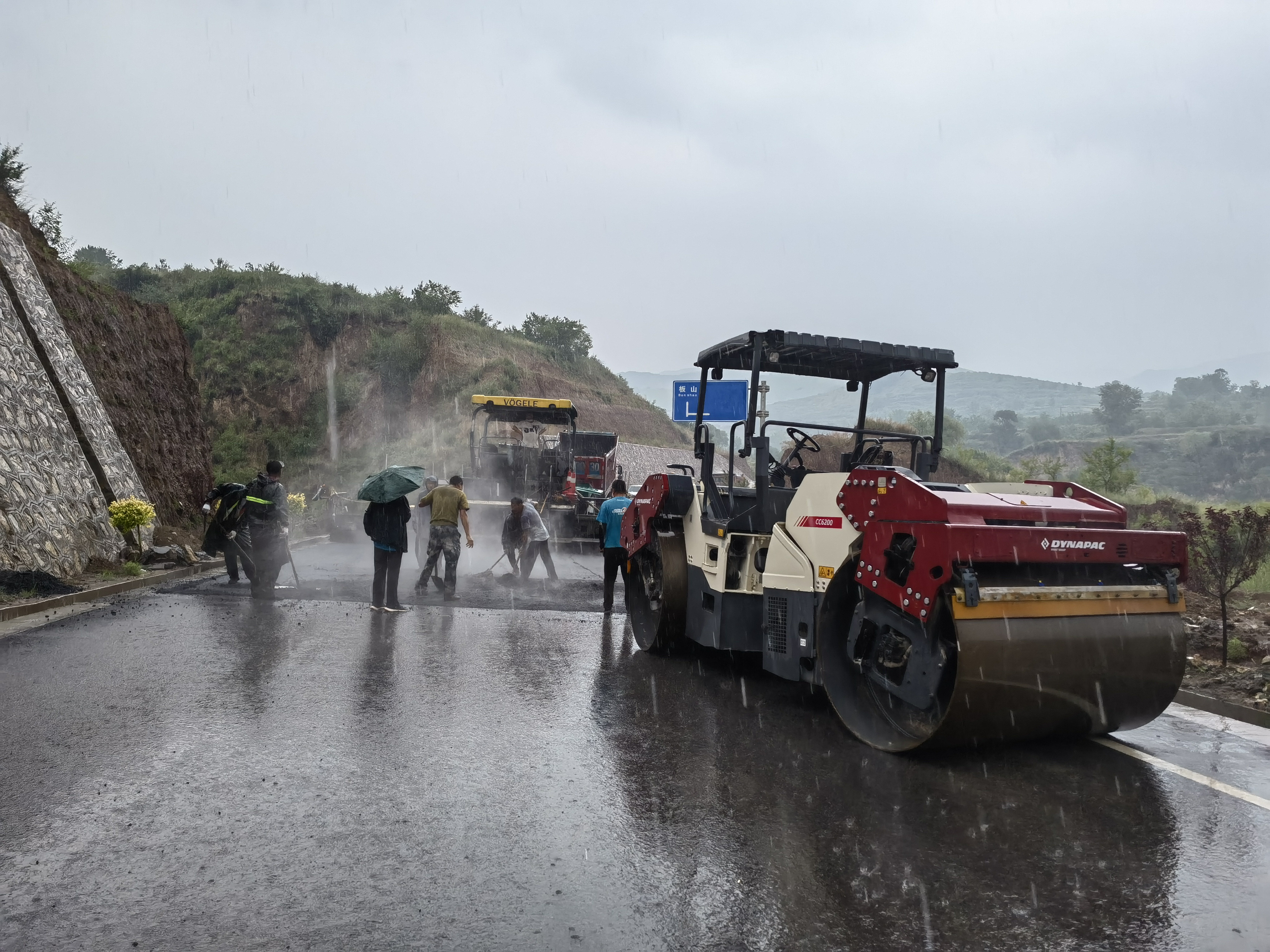 路橋工人在大雨中搶修道路。李華英 攝