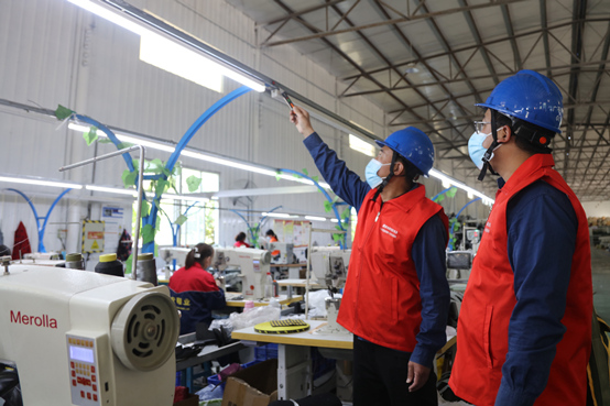 國網廣平縣供電公司共產黨員服務隊到當地服裝加工企業了解企業用電需求，幫助企業排查安全用電隱患。施振宇攝