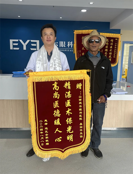 達瓦老人向吳四華（左）贈送錦旗。受訪者供圖