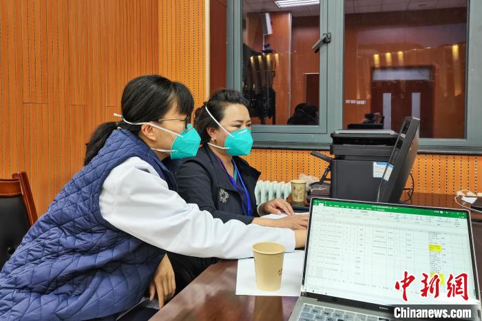 8月9日，楊蘇喬(左)在拉薩方艙醫院指揮部讀取艙內患者胸部CT。　受訪者供圖
