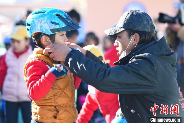 圖為拉薩市實驗幼兒園孩子在教練的幫助下穿戴頭盔?！『闻罾?攝