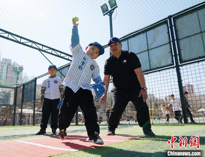 圖為來自臺灣的棒球教練劉興鴻(右)指導(dǎo)小棒球手?jǐn)S球技術(shù)。　馬銘言 攝