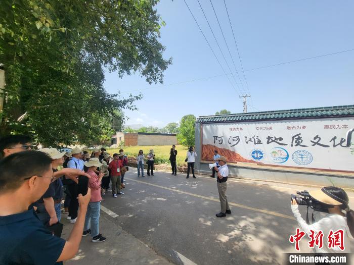 圖為中國地質(zhì)大學(北京)教授張緒教介紹村落情況。　胡友軍 攝