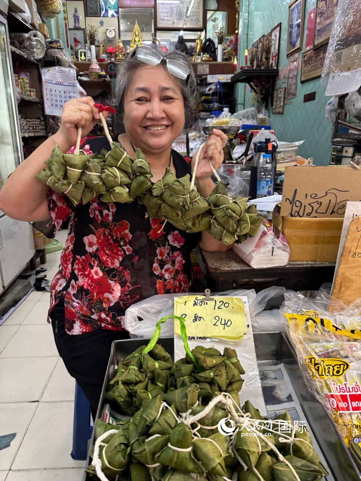 商家向顧客介紹“吉掌”（粽子的一種，一串一串，個頭較小）。人民網記者 簡承淵攝