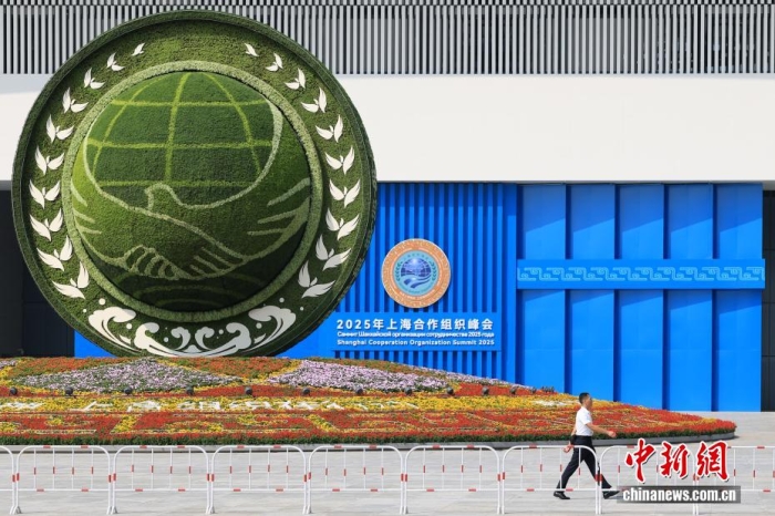 8月31日，天津，一名工作人員從2025年上海合作組織峰會(huì)主會(huì)場(chǎng)外的景觀花壇旁經(jīng)過。當(dāng)日，2025年上海合作組織峰會(huì)在天津舉行。<a target='_blank' href='/'><p  align=
