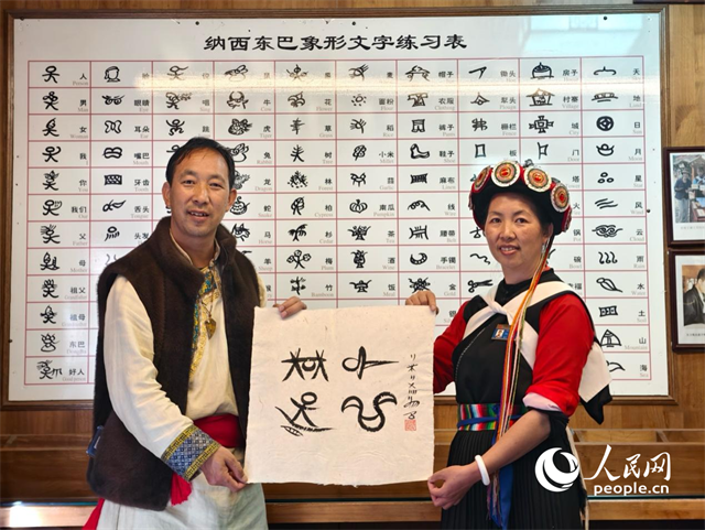 人民網(wǎng)“行進中國”云南調(diào)研采訪團走進麗江，和閏元現(xiàn)場用東巴文寫下“行進中國”。人民網(wǎng)記者 符皓攝