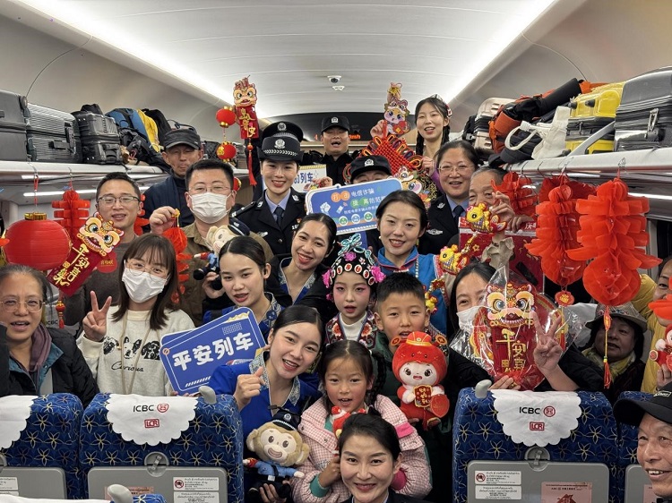 春節(jié)期間，在中老鐵路磨萬（磨丁—萬象）段，鐵路客運員工與乘客合影留念。李加勇攝