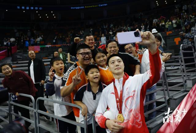 11月12日，十五運會男籃成年組決賽，廣東隊獲得冠軍后，胡明軒與球迷們合影留念。張由瓊 攝