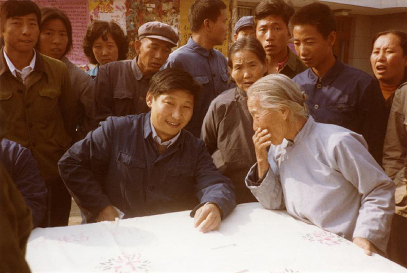 1983年，時(shí)任河北正定縣委書記的習(xí)近平（前排居中），臨時(shí)在大街上擺桌子聽取老百姓意見。