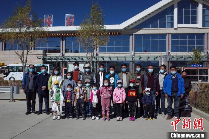 10位接受先心病治療的孩子及家長、工作人員等在日喀則和平機場合影?！〗w波 攝