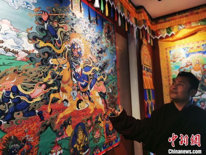 圖為久美尖措展示唐卡作品。　張?zhí)砀?攝
