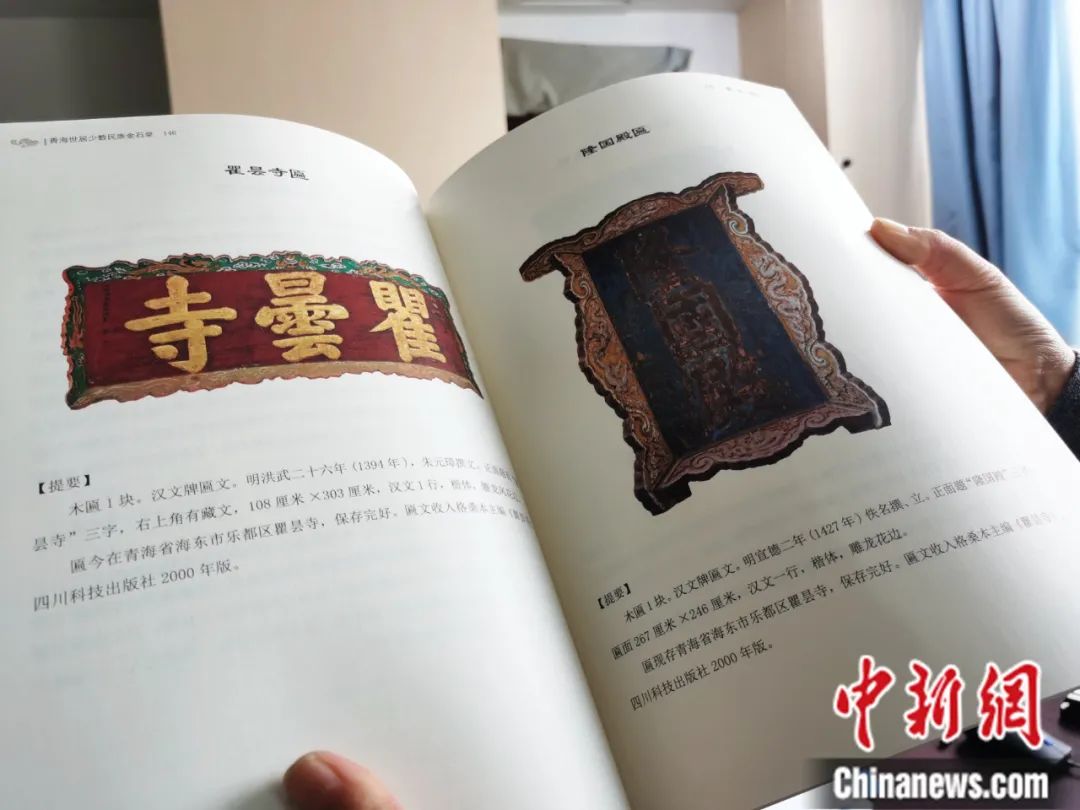 古籍保護人員展示介紹明代朱元璋撰寫的青海瞿曇寺匾(左)的出版書籍。張添福 攝