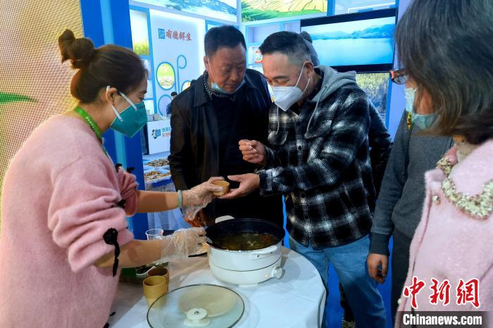 圖為杭州市民品嘗茶卡羊肉。 李雋 攝