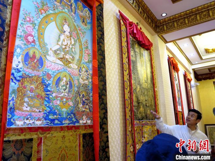 圖為完德尖措展示熱貢龍樹畫苑內的唐卡。　張添福 攝