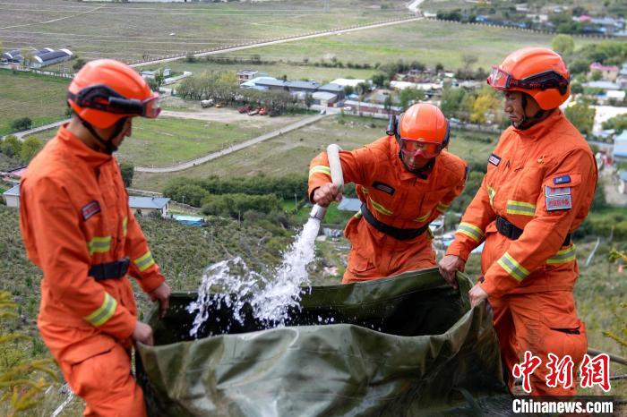 技能大練兵過程中，消防員在陡坡上向蓄水池注水?！±顕鵂c 攝