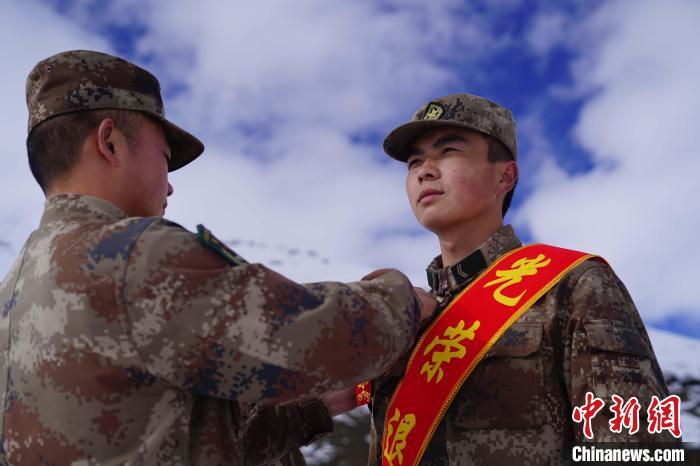 排長王朝偉(圖左)給退伍老兵佩戴大紅花?！∥鞑厣侥宪姺謪^(qū)某團(tuán)供圖