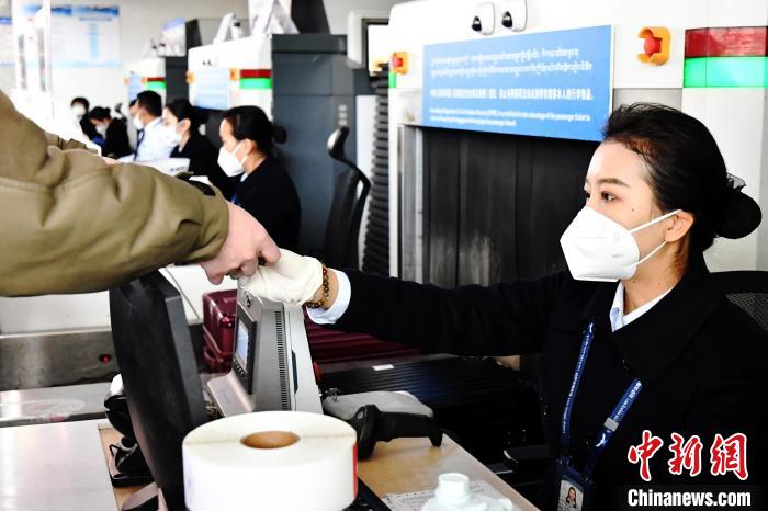 圖為機(jī)場工作人員為旅客辦理行李托運(yùn)。　周航 攝
