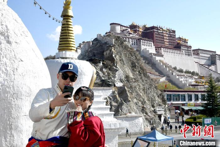4月17日，游客身著藏式元素服裝在拉薩布達拉宮觀景臺拍照留念?！±盍?攝