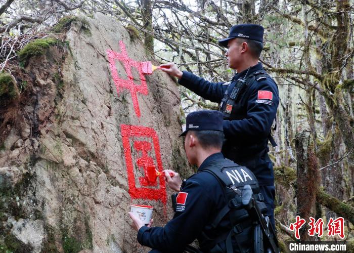 山南邊境管理支隊(duì)玉麥邊境派出所民警邊境巡邏途中在石頭上用油漆涂寫(xiě)“中國(guó)”二字 。　鄭琦山 攝