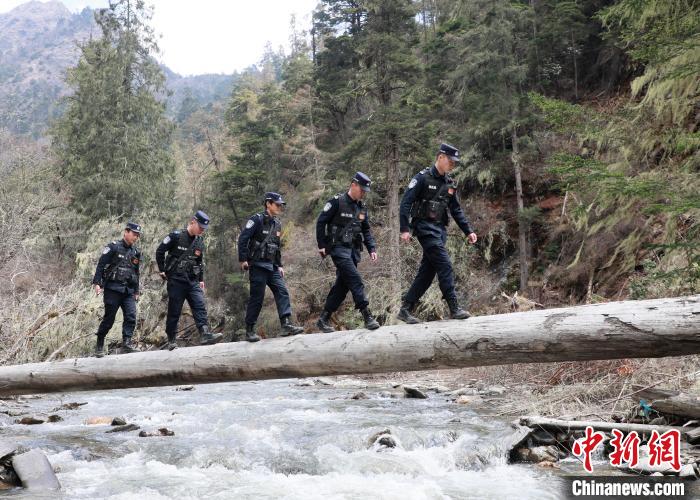 山南邊境管理支隊(duì)玉麥邊境派出所民警邊境巡邏途中走過(guò)河道上“獨(dú)木橋”。　鄭琦山 攝