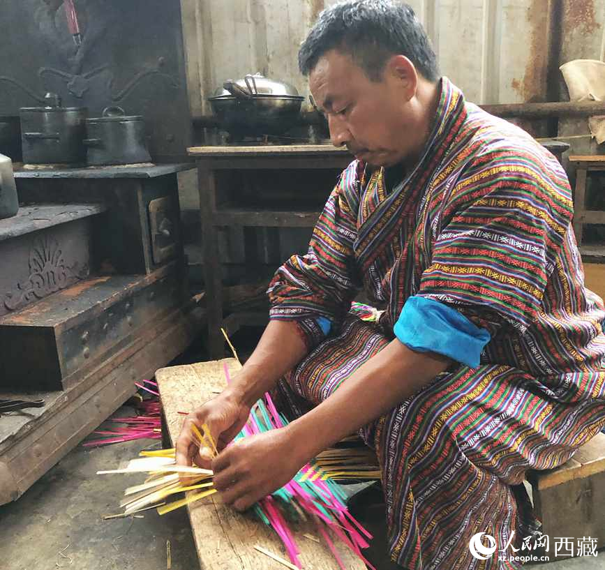 門巴族漢子愛(ài)明正在編織藤竹品。