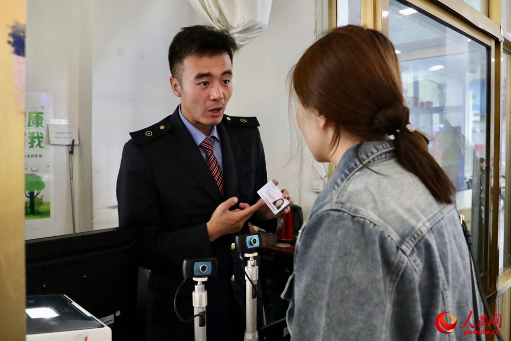 車站工作人員向旅客解答疑問(wèn)。人民網(wǎng)記者 次仁羅布攝
