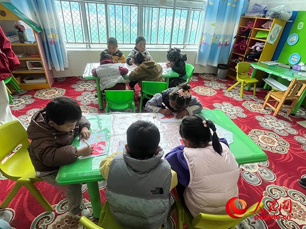 拉多村一所現(xiàn)代化幼兒園小班孩子們正在繪畫。張敏穎 攝