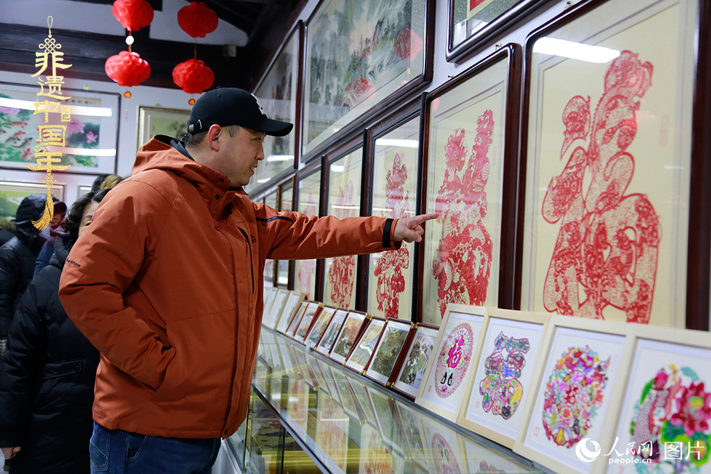 2025年1月23日，游客在天津楊柳青古鎮欣賞傳統剪紙作品，感受指尖上的古老藝術。人民網記者 崔新耀攝